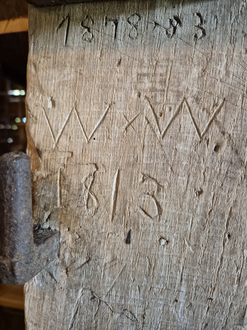 Initials W:W and dates 1813 and 1878 carved into a wooden beam