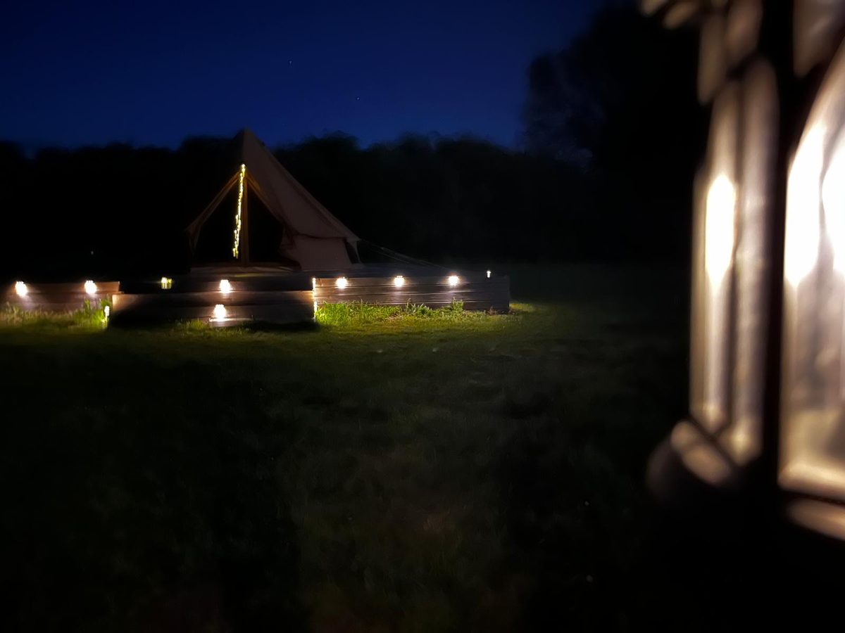 Bell tent at Flint Hall lit at night